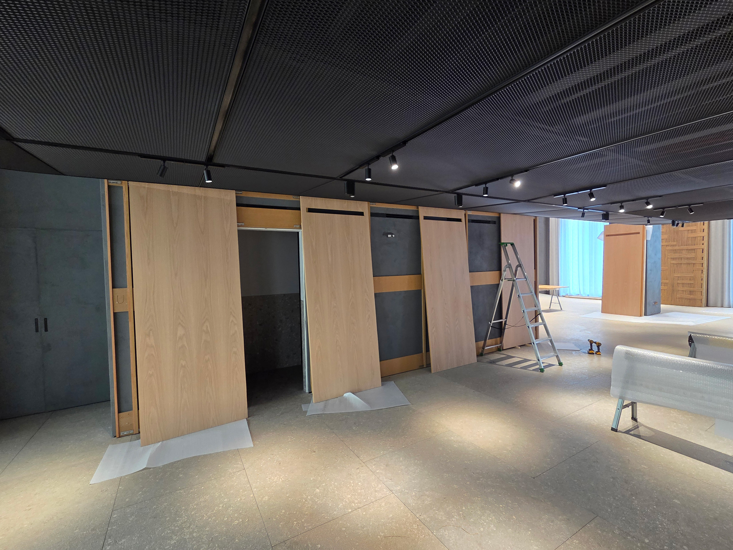 Milano Design Week 2025 – Flexform Moscova, pareti espositive in installazione Montaggio di pannelli espositivi in legno nello store Flexform Moscova durante l’allestimento per Milano Design Week 2025
