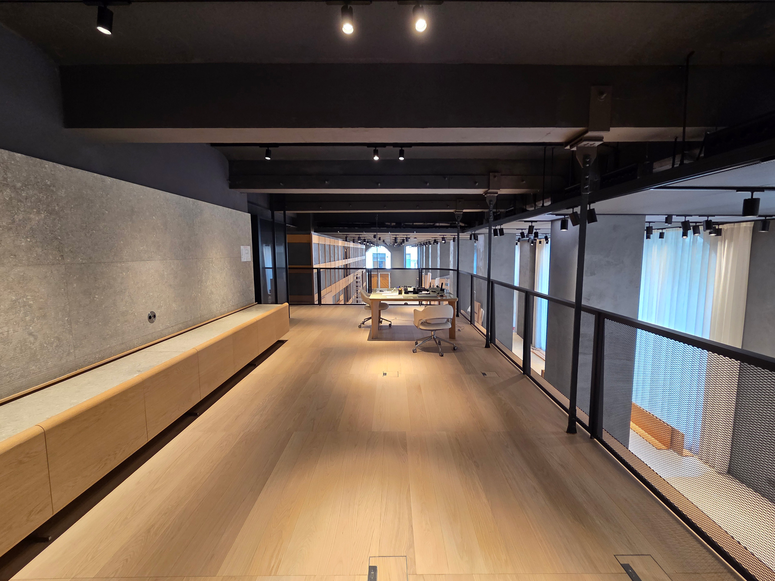 Milano Design Week 2025 – Flexform Moscova, area soppalco Soppalco dello store Flexform Moscova con pavimento in rovere, parapetto metallico e pareti materiche durante l’allestimento MDW 2025