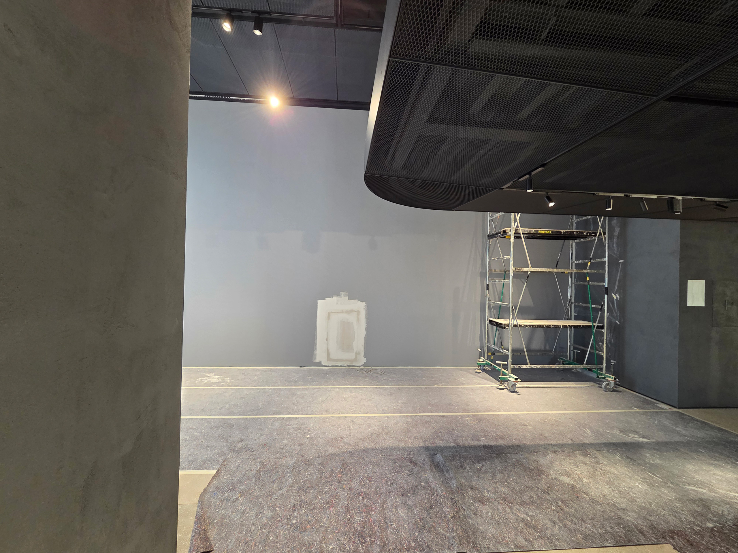 Milano Design Week 2025 – Flexform Moscova, area espositiva in preparazione Spazio interno dello store Flexform Moscova con pareti neutre e ponteggio durante l’allestimento per la Milano Design Week 2025