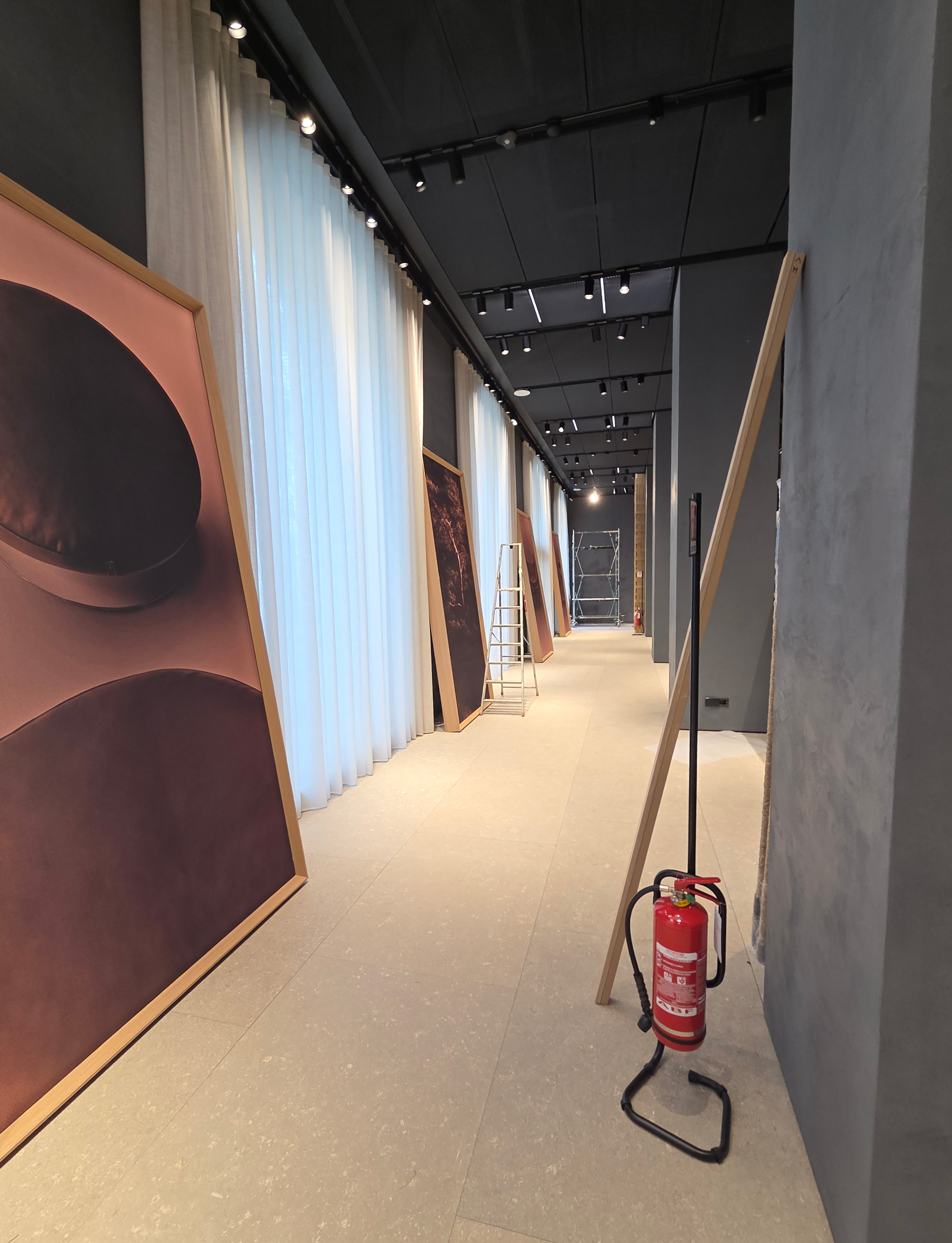 Milano Design Week 2025 – Flexform Moscova, corridoio in allestimento Corridoio dello store Flexform Moscova con pannelli espositivi appoggiati e attrezzature durante l’allestimento per la Milano Design Week 2025