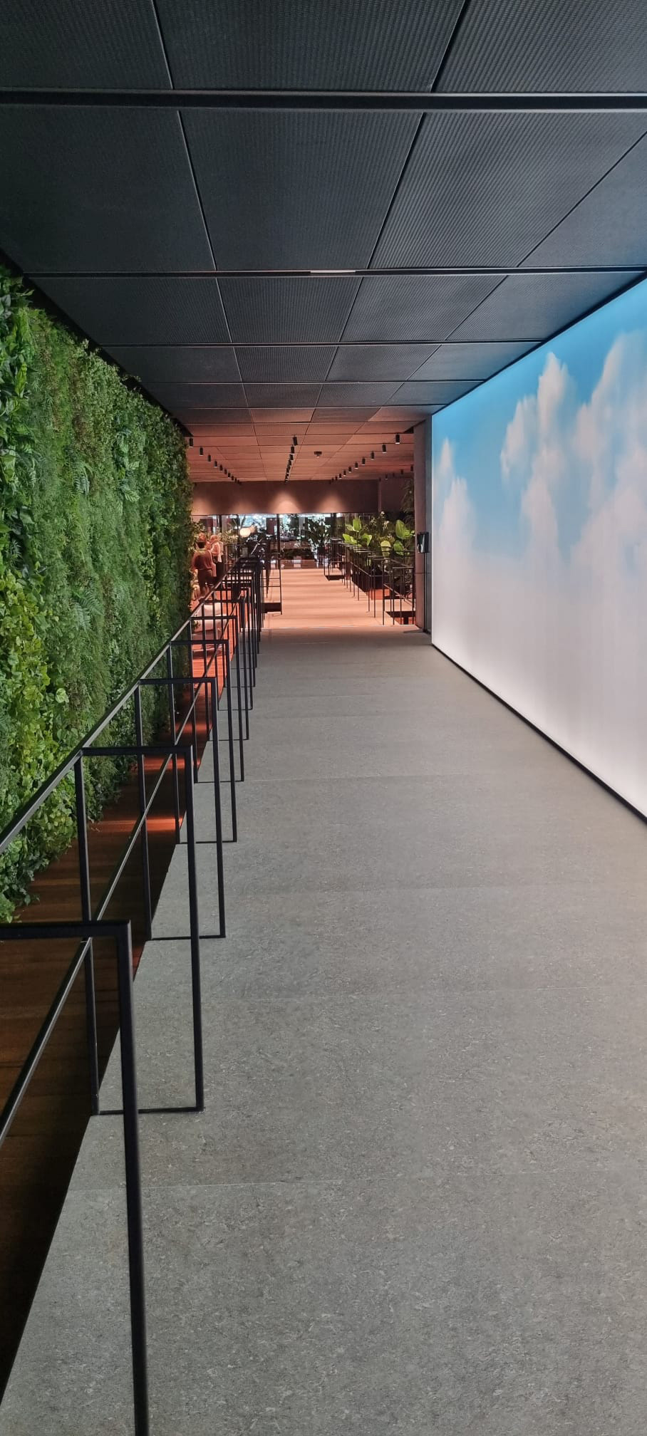 Showroom Flexform Meda – percorso con giardino verticale Corridoio showroom Flexform Meda con parete verde e parapetti metallici