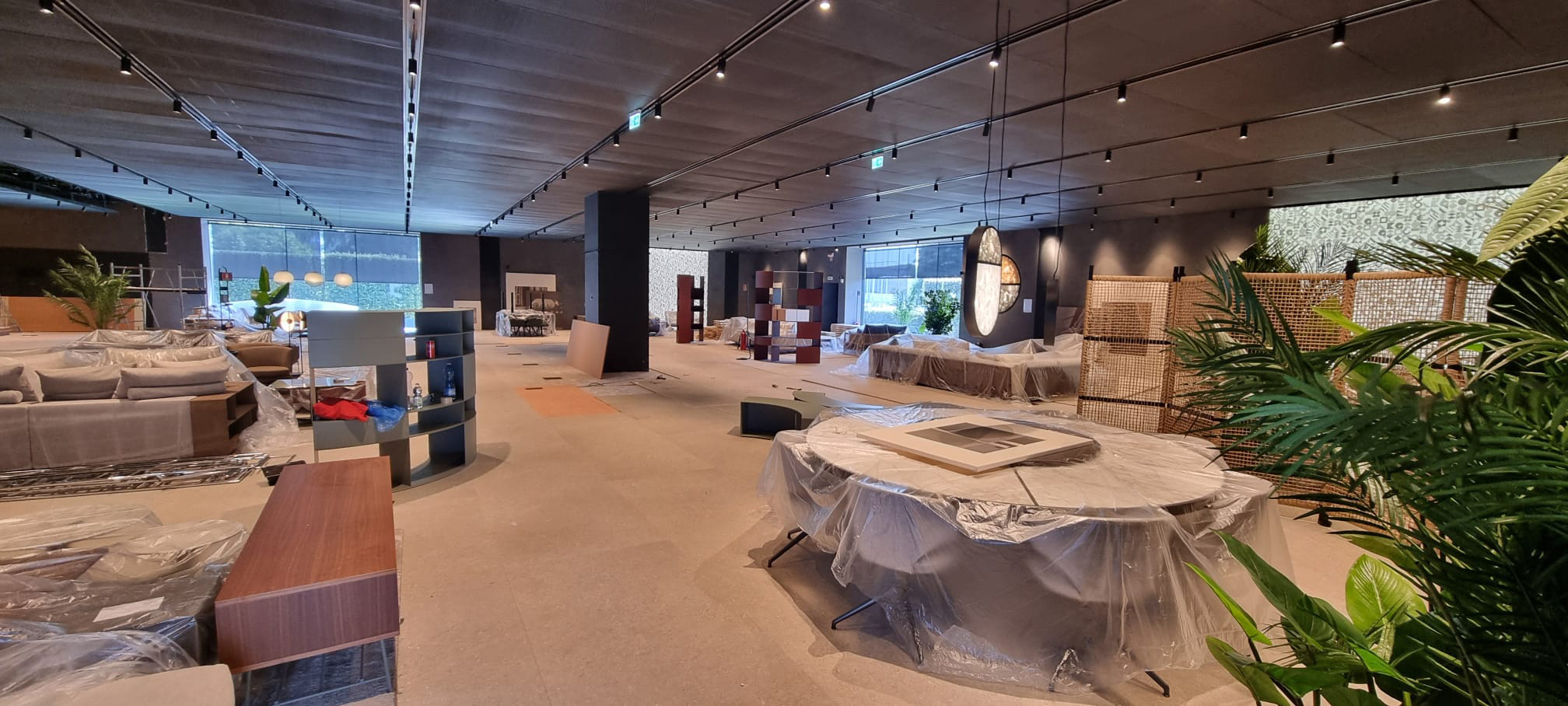 Showroom Flexform Meda – area espositiva durante il montaggio Showroom Flexform Meda in allestimento con arredi coperti e partizioni espositive